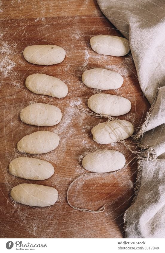 Ungekochte Brötchen auf dem Holztisch ungekocht Teigwaren roh Bäckerei Tisch Lebensmittel Gebäck frisch Küche Koch lecker Form hölzern Mahlzeit Ernährung Brot