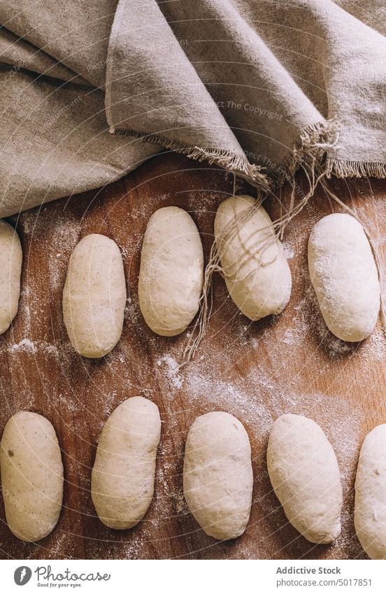 Ungekochte Brötchen auf dem Holztisch ungekocht Teigwaren roh Bäckerei Tisch Lebensmittel Gebäck frisch Küche Koch lecker Form hölzern Mahlzeit Ernährung Brot