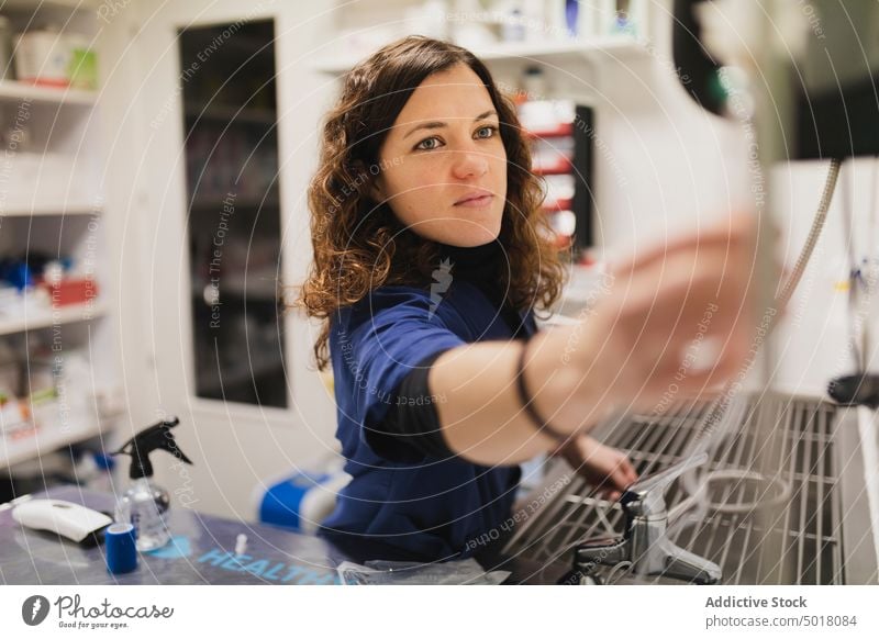 Arzt bei der Benutzung von Geräten im Behandlungsraum Uniform medizinisch Raum jung Frau benutzend Gesundheit Medizin Pflege Krankenhaus Veterinär Klinik Labor