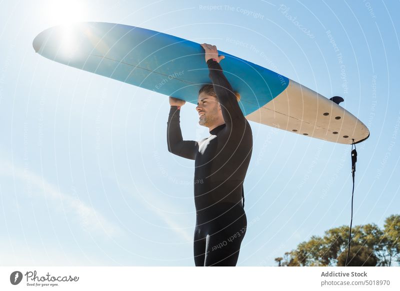 Surfer am Strand mit Surfbrett Mann Natur Sonnenuntergang winken im Freien Neoprenanzug Meeresküste männlich Brandung Sportler MEER Surfen Hobby tragen Seeküste