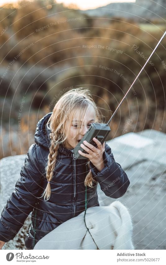 schönes junges Mädchen benutzt ein Walkie-Talkie im Wald reden Kind männlich Mitteilung Spielplatz Spielen grün Porträt blau Radio niedlich Spaß Funkgerät