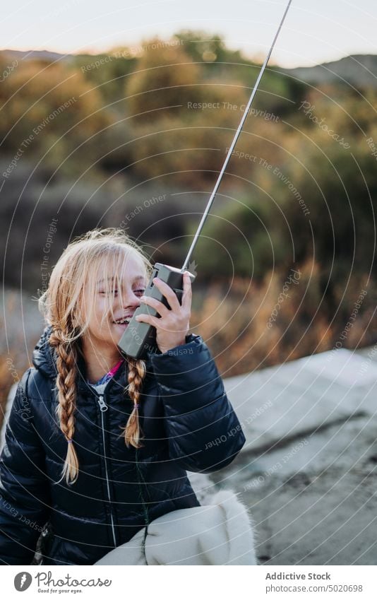 schönes junges Mädchen benutzt ein Walkie-Talkie im Wald reden Kind männlich Mitteilung Spielplatz Spielen grün Porträt blau Radio niedlich Spaß Funkgerät