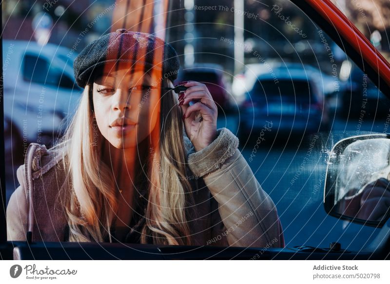 Ethnische Frau trägt Make-up in der Nähe des Autos auf Außenspiegel anwendend Wimperntusche Afroamerikaner jung Großstadt Straße PKW Reflexion & Spiegelung