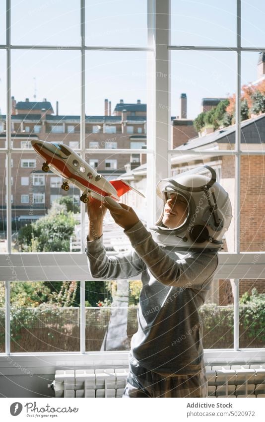 Entzückendes Kind mit Helm, das mit einem Spielzeugflugzeug spielt Astronaut Hintergrund Junge Kindheit Konzept Tracht Schaffung handgefertigt Schutzhelm