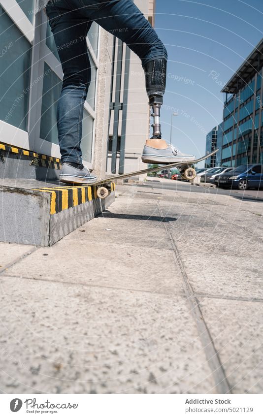 Skater mit Beinprothese springt auf der Straße Mann Skateboard springend Motivation Prothesen künstlich Trick Tatkraft Herausforderung Gebäude Großstadt Glied