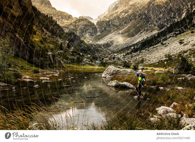 Rucksacktourist beim Überqueren eines flachen Gebirgsflusses Reisender Berge u. Gebirge Fluss Felsen Backpacker Natur Landschaft strömen Abenteuer Hochland