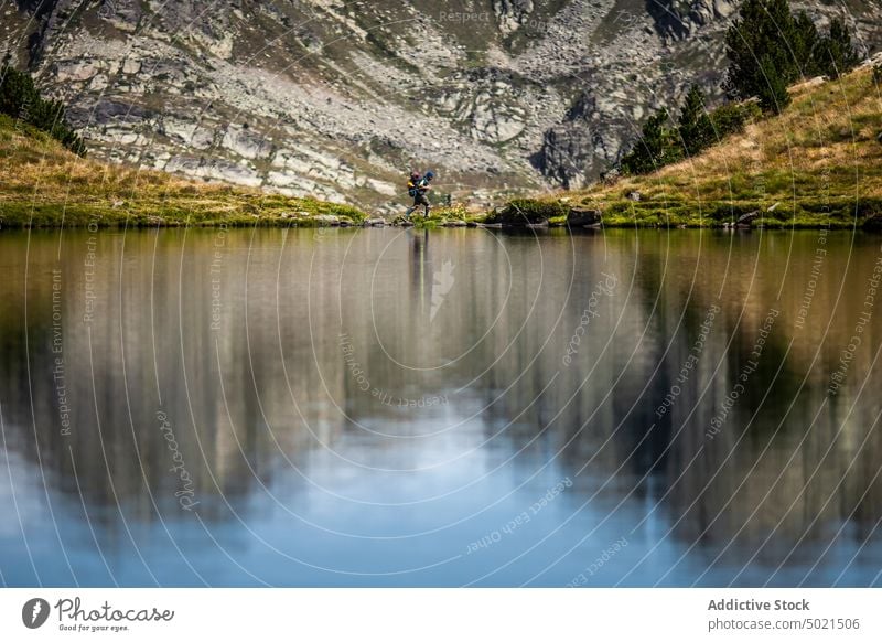 Rucksacktourist beim Überqueren eines flachen Gebirgsflusses Reisender Berge u. Gebirge Fluss Felsen Backpacker Natur Landschaft strömen Abenteuer Hochland