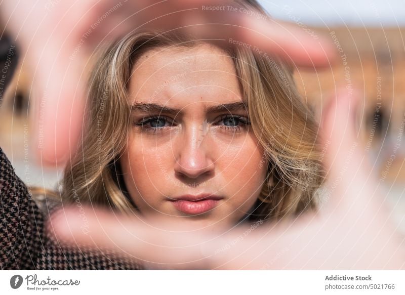 Frau zeigt Umrahmungsgesten und schaut in die Kamera Rahmen gestikulieren Foto Zeichen Symbol Großstadt Phantasie sonnig zeigen Sevilla Plaza de España Spanien