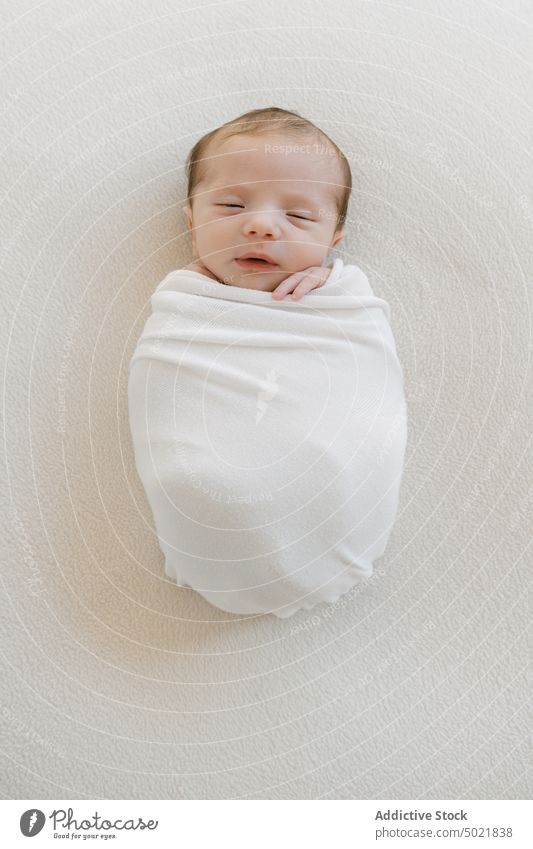 Niedliches Kleinkind in Decke eingewickelt Baby umhüllen schlafen Säugling weich Angebot unschuldig niedlich wenig Kind Lügen Kindheit bezaubernd friedlich