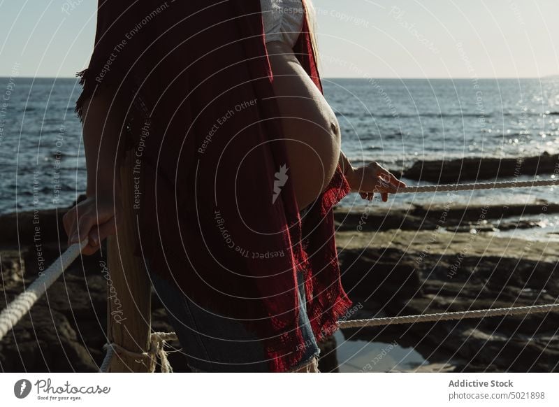 Anonyme schwangere Frau ruht sich am Meer aus ruhen MEER Küste Sommer Wochenende Urlaub Hut lässig Blauer Himmel Strand Bauch mütterlich tagsüber Resort Ufer