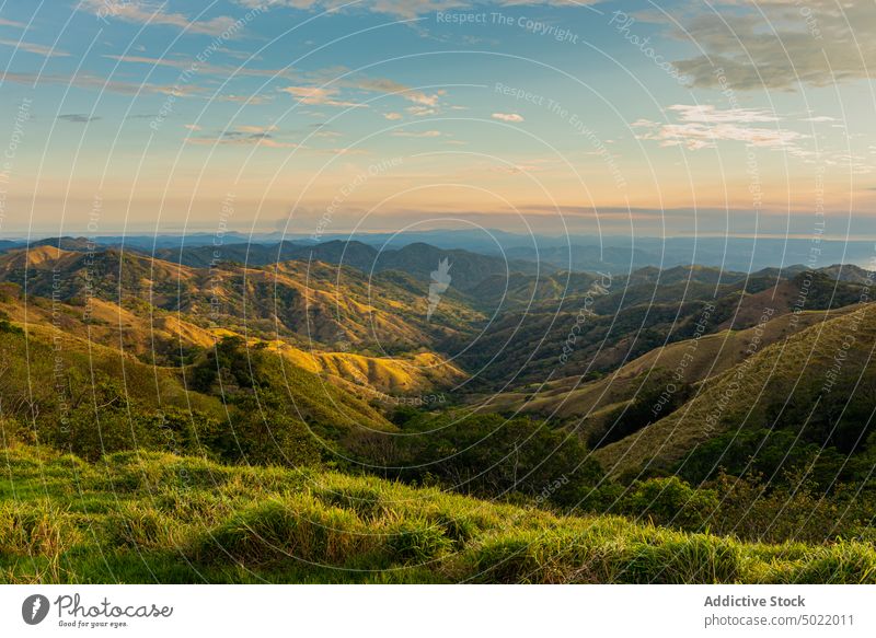 Bergkette mit Gras unter bewölktem Himmel bei Sonnenuntergang Berge u. Gebirge Ambitus Natur Hochland Landschaft Umwelt Ökologie wolkig unberührt Reittier hoch