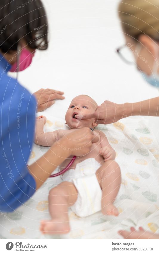 Ein Baby liegt auf dem Rücken, während sein Arzt es bei einer Standarduntersuchung untersucht Säugling Junge Kinderärztin Stethoskop Herzschlag Kindheit Medizin