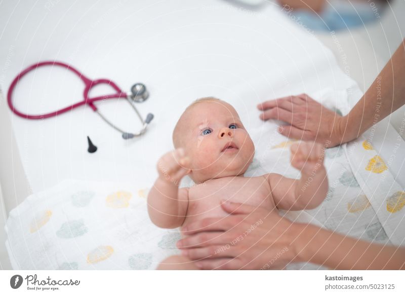 Ein Baby liegt auf dem Rücken, während sein Arzt es bei einer Standarduntersuchung untersucht Säugling Junge Kinderärztin Stethoskop Herzschlag Kindheit Medizin