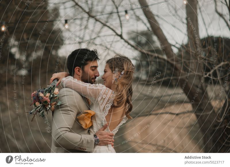 Mann umarmt Frau mit Blumenstrauß umarmend Valentinsgruß Kleid Hochzeit Paar Dame Typ Anzug Haufen Hand jung Baum Liebe Heirat Party Feier Zusammensein