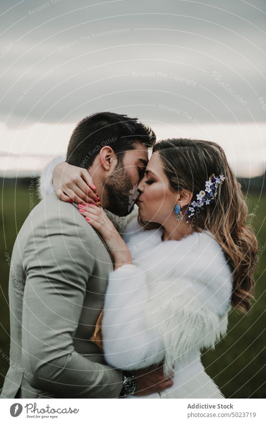 Mann küsst Braut bei Winterhochzeit Frau umarmend Valentinsgruß Blumenstrauß Kleid Mantel Hochzeit Paar Dame Typ Anzug Haufen Hand jung Baum Liebe Heirat Party