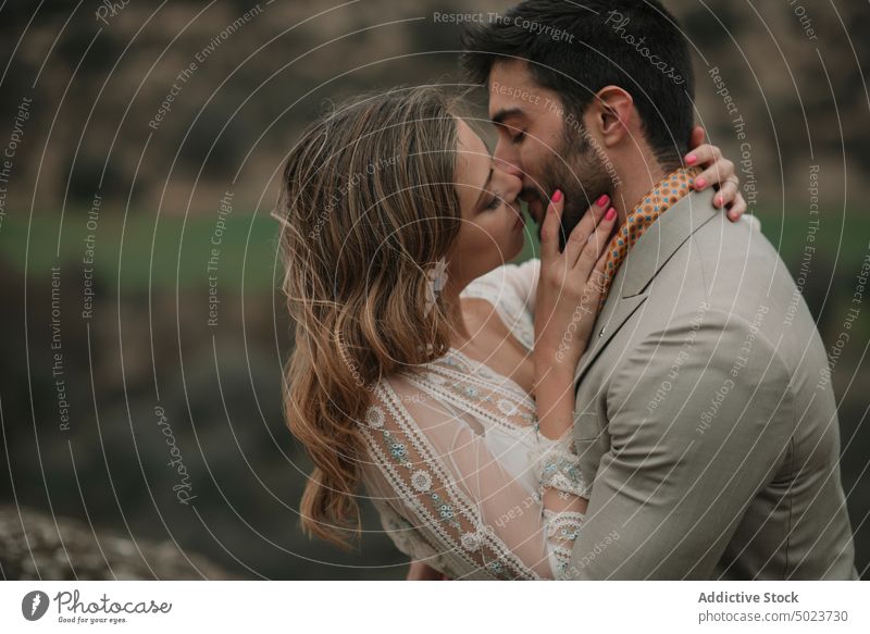 Mann küssend und umarmend mit Frau Küssen Valentinsgruß Hochzeit Paar Dame Typ Kleid Anzug geschlossene Augen jung Liebe Heirat Party attraktiv gutaussehend