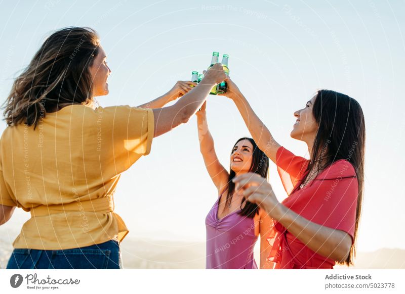 Glückliche Freunde stoßen mit Bierflaschen an Frauen Klirren Zuprosten Freude Freundin Spaß jubelt Flasche Menschengruppe sich[Akk] sammeln trinken Alkohol