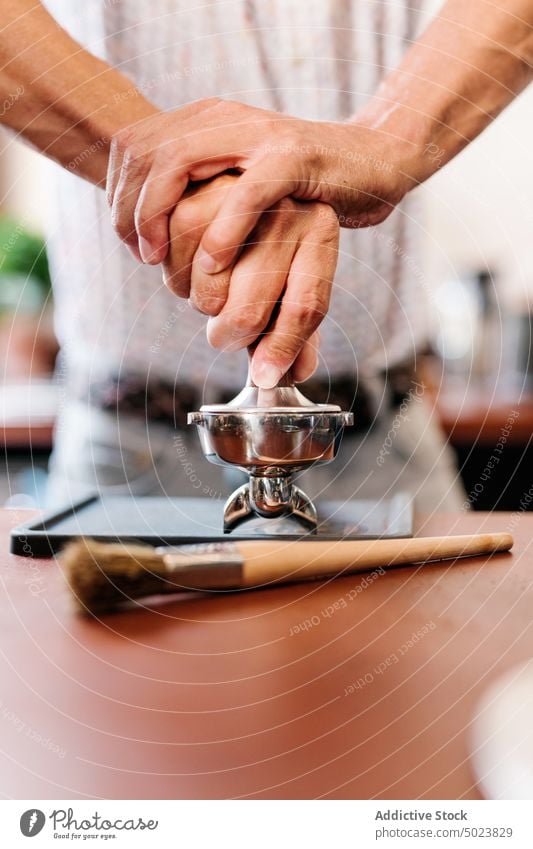 Barista presst Kaffee in den Filter Pressen Portafilter frankieren Café Werkstatt Barkeeper brauen Espresso Getränk Restaurant Herstellung Abfertigungsschalter