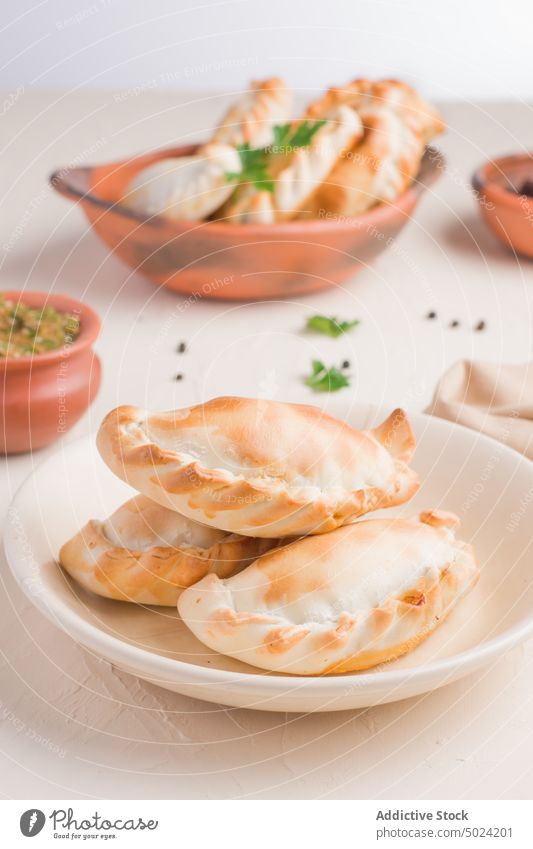 Leckere argentinische Empanadas in Schale mit Sauce empanada chimichurri Saucen gebraten Küche dienen selbstgemacht Lebensmittel Petersilie Piment geschmackvoll