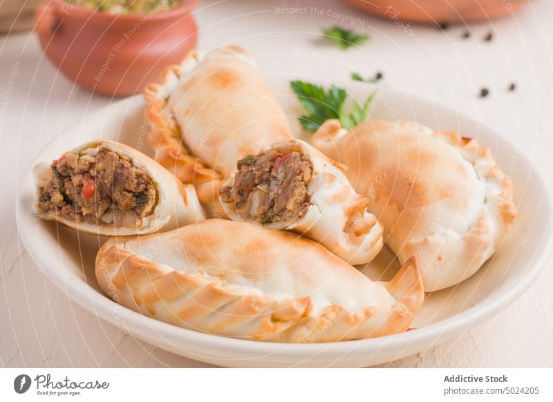 Leckere argentinische Empanadas in Schale mit Sauce empanada chimichurri Saucen gebraten Küche dienen selbstgemacht Lebensmittel Petersilie Piment geschmackvoll