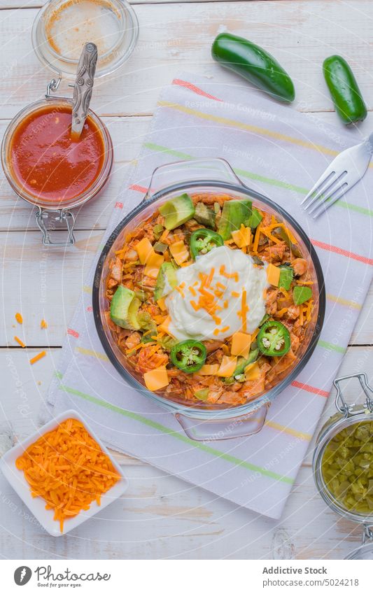 Schüssel mit leckerem Hühnersalat-Enchilada auf den Tisch gestellt Lebensmittel Hähnchen Sauerrahm Salatbeilage Schalen & Schüsseln Ernährung Gemüse Jalapeno