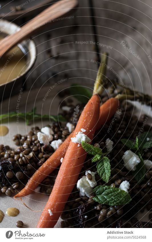 Servierte Teller mit Bio-Salat auf dem Holztisch Platten Salatbeilage Linsen serviert Möhre organisch Dressing grün rustikal Tisch Holzplatte hölzern frisch