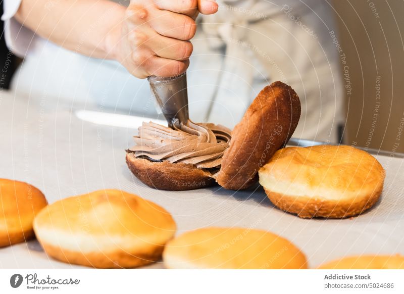 Unbekannter Bäcker, der in der Küche Sahne auf Torten gibt Kuchen Koch Dessert Backwarenbeutel Gebäck Veganer Schwamm Bäckerei Schokolade lecker kulinarisch