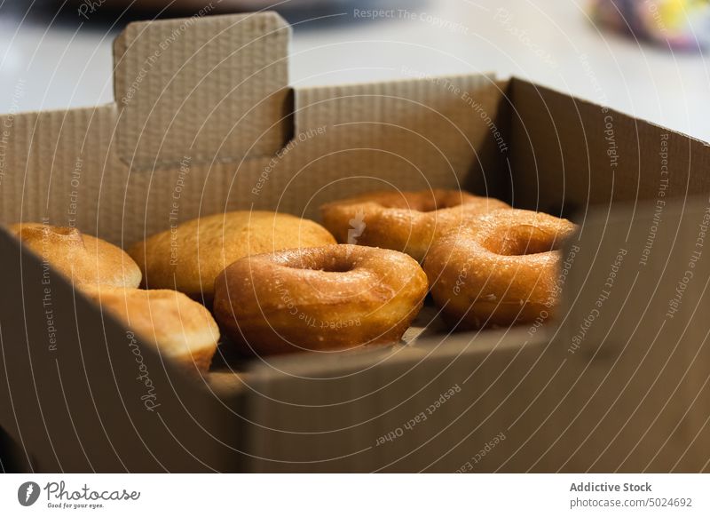 Süße Donuts in einer Kartonschachtel in einer Bäckerei Doughnut Kasten Imbissbude Krapfen berliner süß Dessert Veganer Leckerbissen Tisch Schachtel frisch