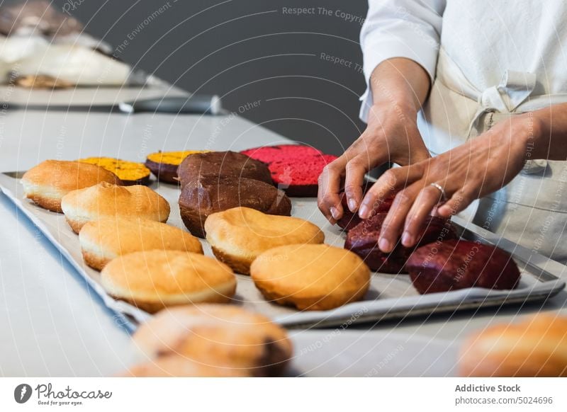 Crop Koch setzen Biskuitkuchen auf dem Tablett in der Küche Bäcker Schwamm Kuchen Dessert vorbereiten Veganer Bäckerei süß lecker Küchenchef geschmackvoll