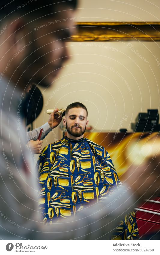 Friseur in einem Friseursalon Friseurstuhl Vollbart Schönheit Pflege Klient Schermaschine geschnitten elegant Behaarung Haarschnitt Hände Kopf im Innenbereich