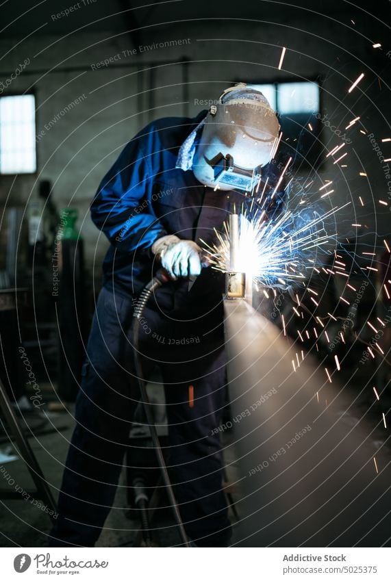 Professioneller Schweißer mit Schutzhelm in der Werkstatt Schweißnaht Metall Mann Maschine dunkel Funken Licht männlich Arbeiter Beruf professionell Werkzeug