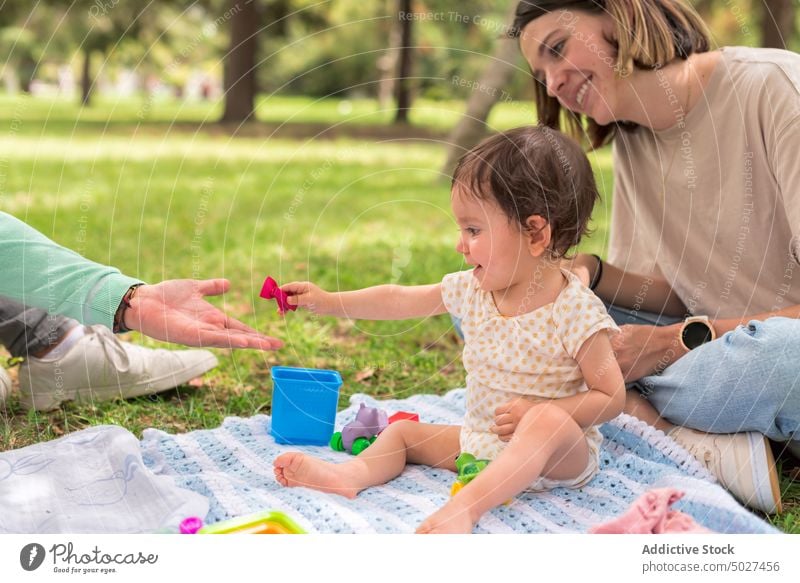 Lächelnde Mutter mit Baby im Gras sitzend Tochter Angebot Bonden Säuglingsalter Park Zuneigung Rasen sorgenfrei Frau Mama Mädchen Natur Zusammensein Kind wenig