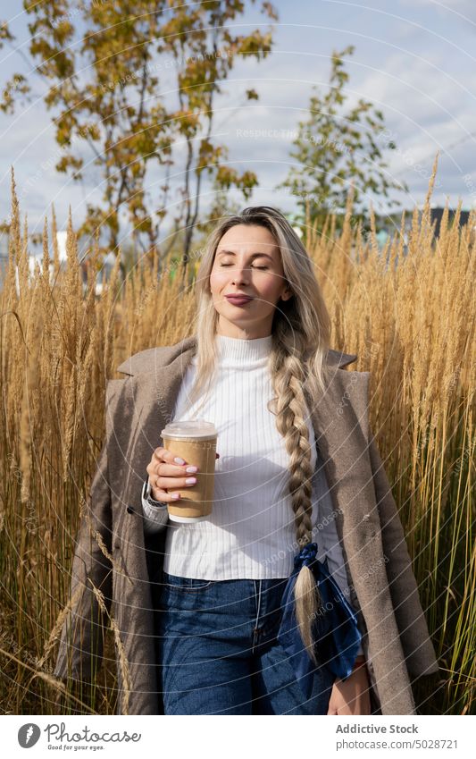 Frau mit Getränk zum Mitnehmen genießt das Sonnenlicht Imbissbude trinken Gras genießen Stil urban Wochenende Windstille Natur Sommer Augen geschlossen Geflecht