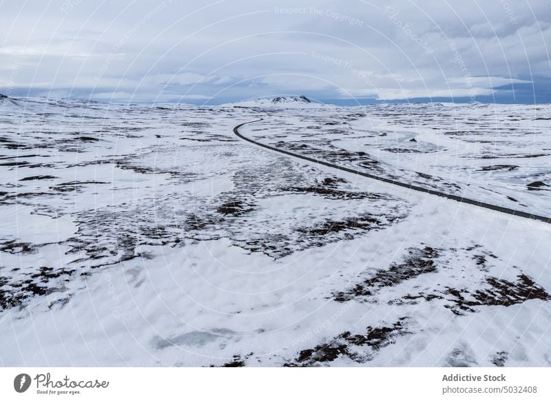 Leere Asphaltstraße inmitten eines schneebedeckten Feldes Straße Winter Landschaft Nacht polar Aurora Island Schnee atemberaubend Kamm Hochland kalt malerisch