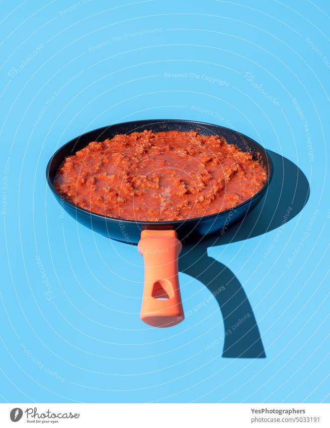 Bolognesesauce in einer Pfanne isoliert auf blauem Hintergrund oben Rindfleisch hell Kohlenhydrate klassisch Nahaufnahme Farbe Essen zubereiten Textfreiraum