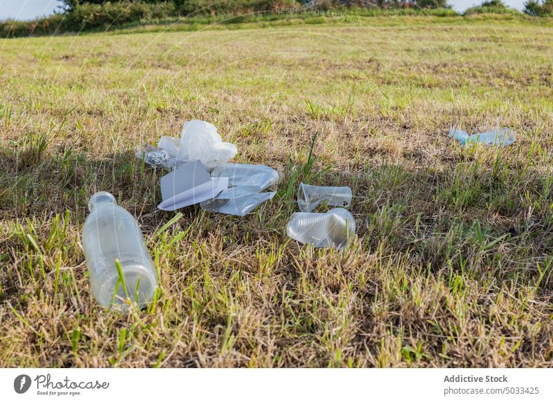 Plastikmüll auf der Wiese Müll Abfall Kunststoff Flasche Tasse Folie verschmutzen verwendet Gras Umwelt Container Ökologie Natur Einwegartikel Feld Rasen