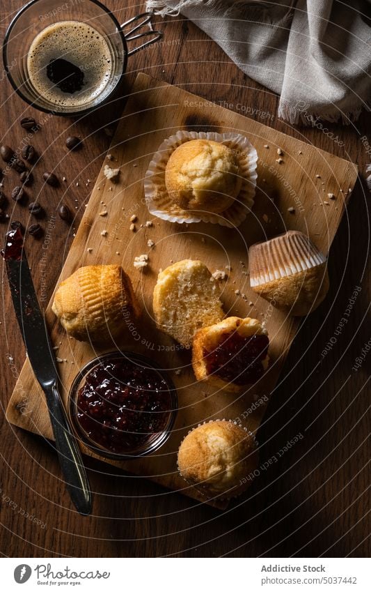 Muffins und Himbeermarmelade auf dem Tisch Kaffee Himbeeren Marmelade Frucht Frühstück Lebensmittel lecker Bäckerei Schwamm Kuchen hölzern Nahaufnahme Textur