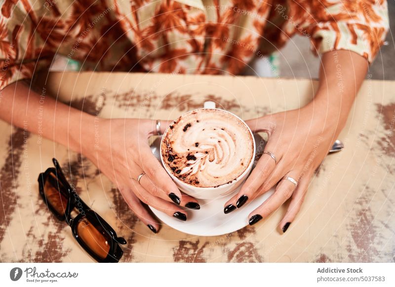 Crop Frau mit leckeren Kaffee im Café Tasse Latte berühren Wochenende Frühstück Kaffeepause Tisch Madrid Spanien Geschmack Koffein Kaffeehaus jung Getränk