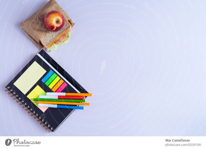 BACK TO SCHOOL mit Notizbuch, Stiften und Sandwich mit Obst. zurück zur Schule Notebook lernen violetter Hintergrund Textfreiraum Klassenraum primär sekundär