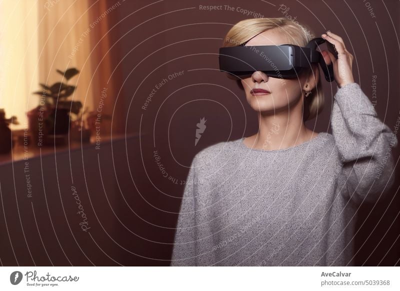 Eine blonde Frau, die ein VR-Headset trägt, um das zukünftige Metaverse zu erkunden. Verbindungskonzept, Kopierraum Person Technik & Technologie horizontal