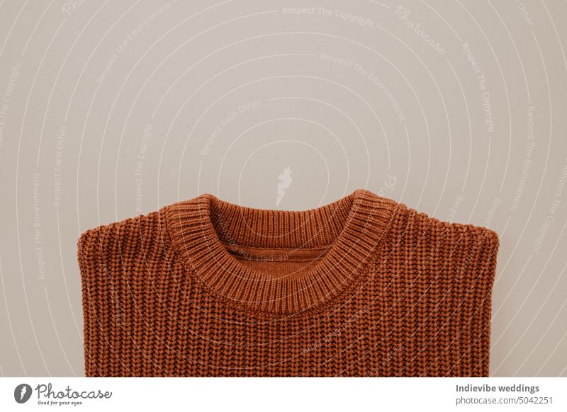 Brauner gestrickter Wollpullover auf beigem Hintergrund. Flat Lay Herbst Mode-Design. Pullover braun Wolle stricken Kleidung Top Textil Stil lässig Bekleidung