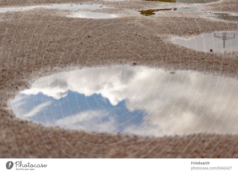 Spiegelung vom blauen Himmel mit weißen Wolken in einer Pfütze Pfützenspiegelung Reflexion & Spiegelung Wasser nass Wetter Außenaufnahme Regen Menschenleer