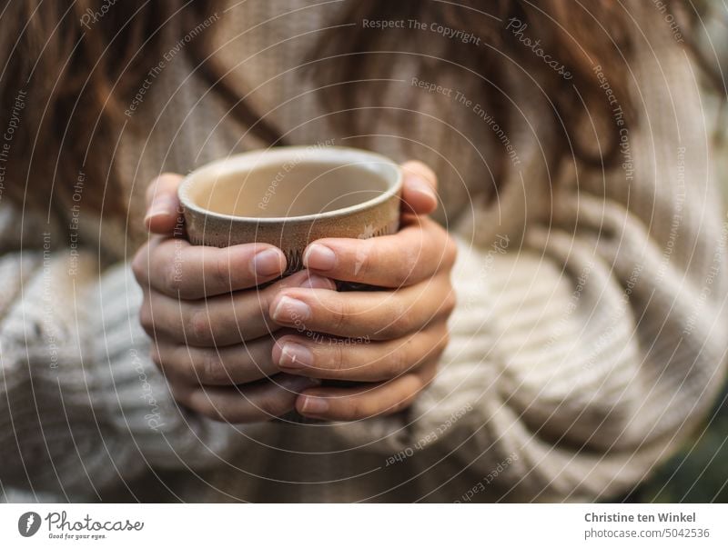 Die kalten Hände am heißen Teebecher aufwärmen Kaffeebecher festhalten wärmend heißer Tee Kälte Heißgetränk Pullover Herbst Winter kalte Jahreszeit gemütlich