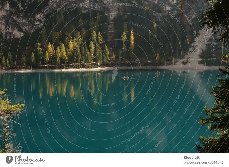 Pragser Wildsee - Spiegelung der Berge und bunt gefärbten Bäume im grünen Wasser ein kleines Boot zieht seine Runde Bergsee grünes Wasser Fels Menschen