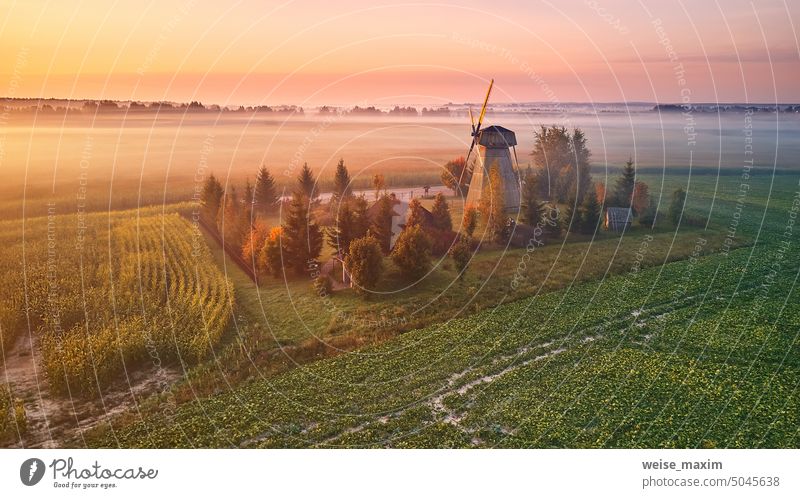 Traditionelle hölzerne Windmühle Morgen Landschaft. Rural bunten Sonnenaufgang, neblige grüne Felder. Dudutki Dorf alt Natur Nebel Architektur ländlich reisen