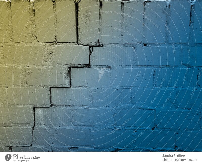 Riss in der Mauer in den Nationalfarben der Ukraine Farben Trennung kaputt Zerstörung Vergänglichkeit Verfall Menschenleer Außenaufnahme Wand Gedeckte Farben