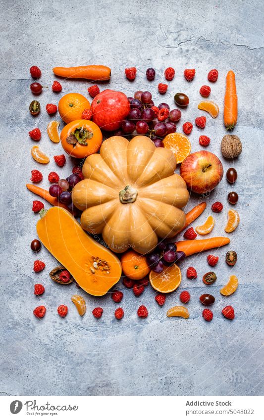 Rohe Kürbisse und gemischtes Herbstgemüse Gemüse fallen sortiert Stillleben Apfel Persimone Ernte frisch Lebensmittel roh Vor dunklem Hintergrund Gesundheit