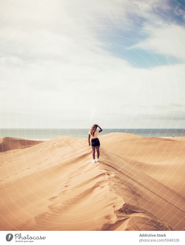 Frau steht auf einer Düne und bewundert das Meer bewundern MEER Strand Tourist erkunden wolkig Blauer Himmel Sand Maspalomas Gran Canaria Kanarische Inseln