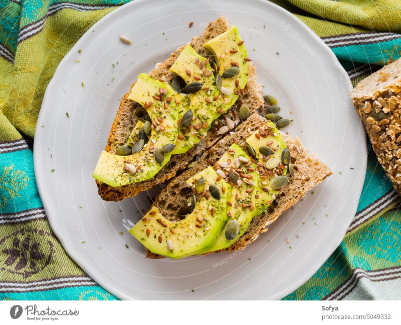 Avocado-Sandwich als gesunder Snack mit Kernen Zuprosten Belegtes Brot Scheibe Lebensmittel Gemüse Gesundheit Müsli Vollkorn Saatgut Kürbis flex essen