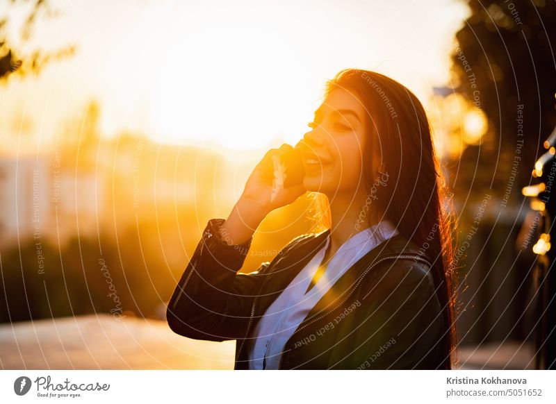 Business-Frau mit Smartphone Nahaufnahme im Herbst Stadt, Sonnenuntergang Licht. Mädchen haben Gespräch mit Handy. Schöne kaukasische junge Frau im Gespräch mit mobilen Gerät